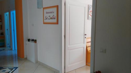 a hallway with a white door with a picture on it at B&b Sa Zodia Guest House in Bitti