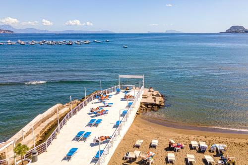 a beach with chairs and umbrellas on the beach at Casa Cicerone Lucrino in Pozzuoli
