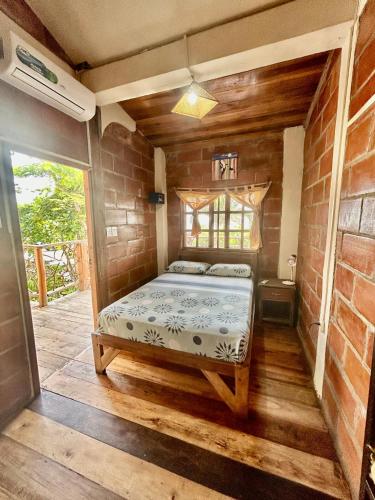 a bedroom with a bed in a brick wall at The Sea Garden House in Olón