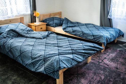 two beds with blue comforters in a bedroom at Agroturystyka całoroczna Ranczo Husinka in Husinka