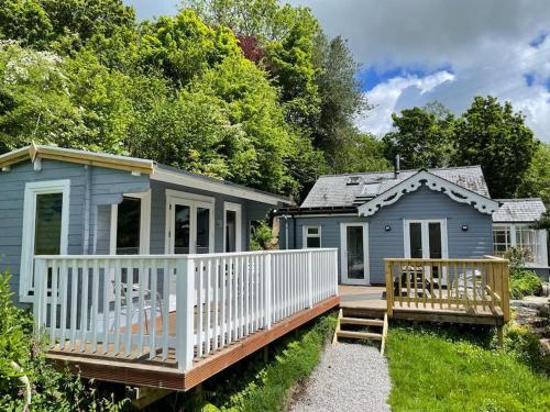 a blue cottage with a porch and a deck at Lower Hill Cottage w/Swedish Hot Tub in Bodmin