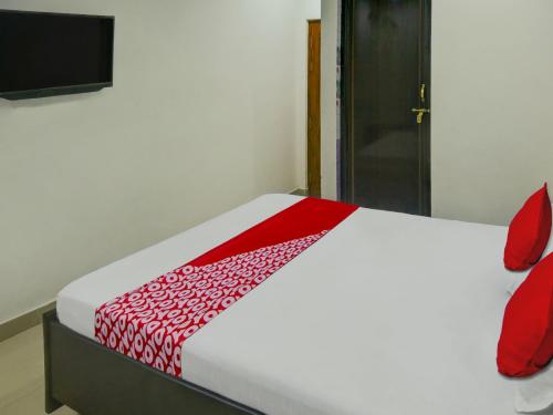 a bedroom with a bed with a red and white comforter at Flagship Hotel The Guest Land in Visakhapatnam