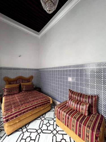 Traditional Riad in Rabat في الرباط: غرفة نوم بسريرين واريكة
