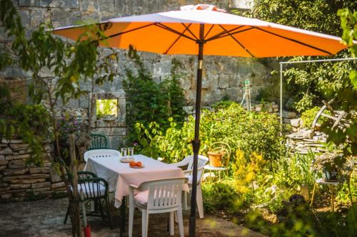 a table with an umbrella in a garden at Holiday house in Zrnovo with terrace, air conditioning, WiFi 3709-2 in Žrnovo