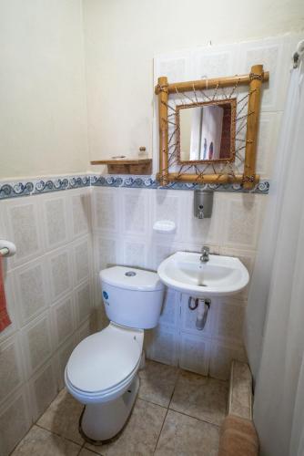 a bathroom with a toilet and a sink at The Sea Garden House in Olón