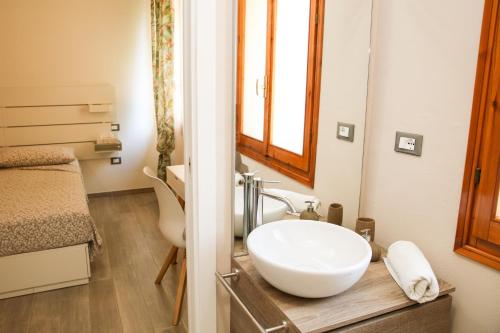 a bathroom with a white sink and a bed at B&B Zvana's - Da Giovanna in Imola