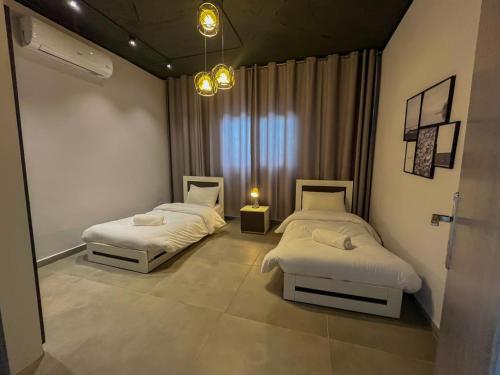 um quarto com 2 camas e um lustre em Trendy house -deadsea em Al Rama