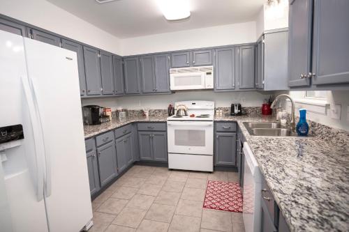 a kitchen with gray cabinets and white appliances at Elegant 3 bedroom apt with free parking and balcony in Nashville