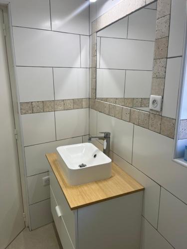 une salle de bain blanche avec un lavabo et un miroir dans l'établissement Leopold housse, à La Ciotat