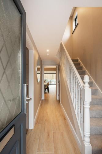 a hallway of a home with a staircase and a door at The Orchard, 5 Star Luxury Accommodation in Newcastle
