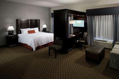 ein Hotelzimmer mit einem Bett, einem Schreibtisch und einem Stuhl in der Unterkunft Hampton Inn and Suites Marksville in Mansura