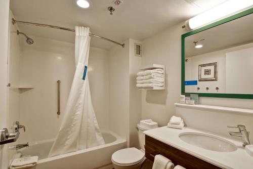 a bathroom with a tub and a toilet and a sink at Hampton Inn Albany-Wolf Road in Albany