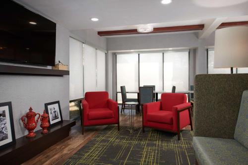a waiting room with red chairs and a table at Hampton Inn Atlanta-Cumberland Mall/Cobb Galleria Area in Atlanta