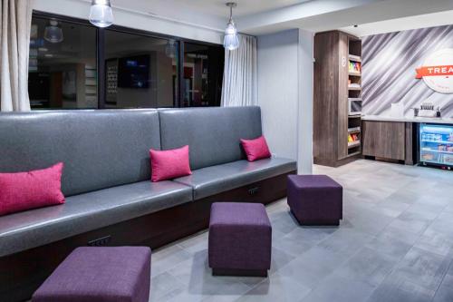a waiting room with a couch and two pink pillows at Hampton Inn Conyers in Conyers