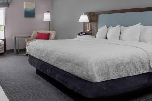 a hotel room with a large bed and a chair at Hampton Inn Conyers in Conyers