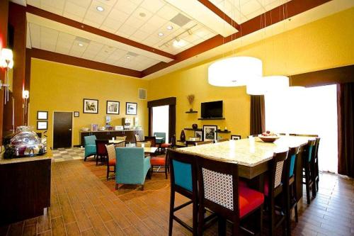 a restaurant with a table and chairs in a room at Hampton Inn Atlanta/Douglasville in Douglasville