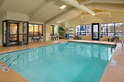 a swimming pool in a hotel with chairs and tables at Hampton Inn Atlanta-Stockbridge in Stockbridge
