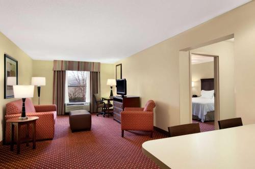a hotel room with a bed and a living room at Hampton Inn Atlanta-Stockbridge in Stockbridge