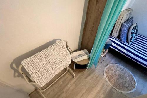 Cette chambre comprend une chaise et un lit. dans l'établissement Studio Serenity - Hyper Centre et Proche Plage - Bus, à Dunkerque