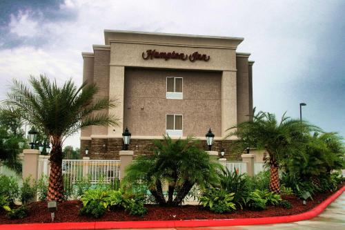 a shopping center with palm trees in front of it at Hampton Inn Orange in Orange