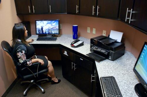 a woman sitting in a chair at a desk with a computer at Hampton Inn Orange in Orange