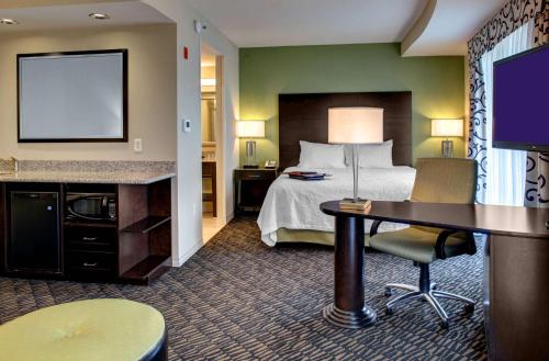 a hotel room with a bed and a flat screen tv at Hampton Inn & Suites Baton Rouge Downtown in Baton Rouge