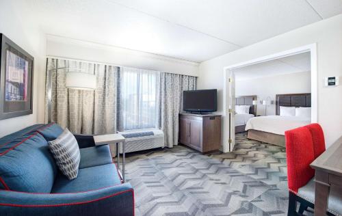 a hotel room with a couch and a bed and a television at Hampton Inn & Suites Atlanta-Galleria in Atlanta