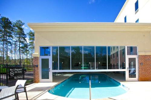 a swimming pool in front of a house at Hampton Inn Atlanta McDonough in McDonough