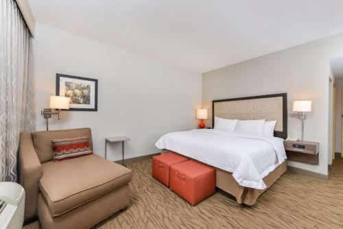 Habitación de hotel con cama y silla en Hampton Inn Gonzales, en Gonzales