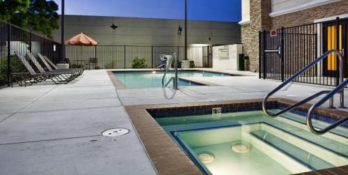 uma piscina com uma banheira de hidromassagem num edifício em Hampton by Hilton em Brentwood