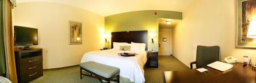 a hotel room with a bed and a desk at Hampton by Hilton in Brentwood