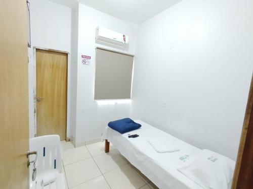 a hospital room with a bed and a window at Hotel Oliveira 44 in Goiânia