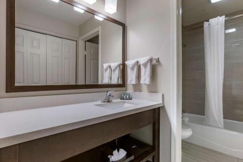 Best Western North Phoenix Hotel في فينكس: حمام مع حوض ومرآة ومرحاض