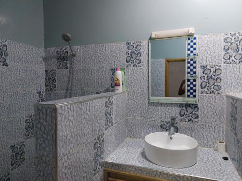 a bathroom with a sink and a mirror at Villa Somone 4 chambres avec Piscine in Somone