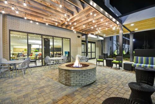 a patio with a fire pit and tables and chairs at Home2 Suites By Hilton Opelika Auburn in Opelika