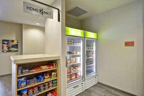 a store aisle with an open refrigerator in a store at Home2 Suites By Hilton Opelika Auburn in Opelika