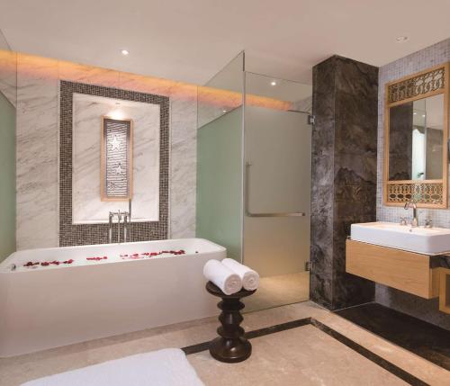a bathroom with a tub and a sink at Thousand Cranes Sanya Yazhou Bay Int'l Exchange Centre in Sanya