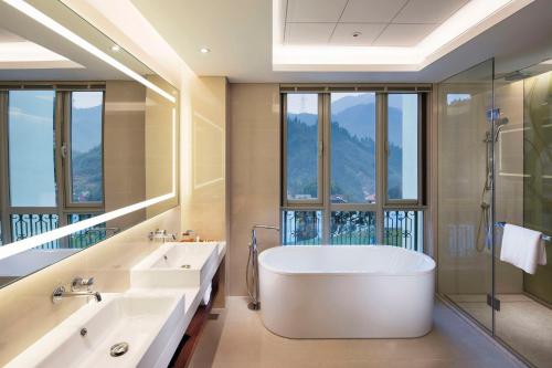 een badkamer met een bad en een groot raam bij Hilton Garden Inn Hangzhou Lu'Niao in Anji