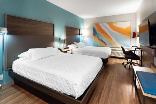 um quarto de hotel com duas camas e uma secretária em Tru By Hilton Greensboro Lake Oconee, Ga em Greensboro