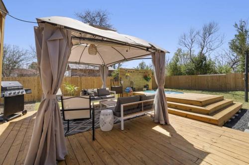 a patio with an umbrella and a grill at Cowboy Pool 2 mins 2 Silos & Cameron Park in Waco