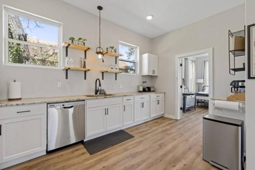 a large kitchen with white cabinets and a hardwood floor at Cowboy Pool 2 mins 2 Silos & Cameron Park in Waco