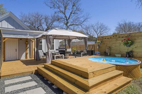 a deck with a swimming pool and an umbrella at Cowboy Pool 2 mins 2 Silos & Cameron Park in Waco