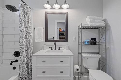 a bathroom with a sink and a toilet and a mirror at Cowboy Pool 2 mins 2 Silos & Cameron Park in Waco