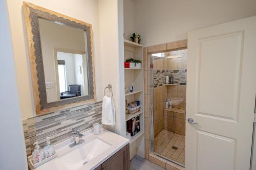 uma casa de banho com um lavatório e um chuveiro com um espelho. em Casablanca 1 em Houston