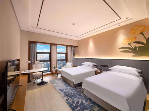 1 dormitorio con 2 camas, escritorio y ordenador en Hilton Garden Inn Anshan, en Anshan