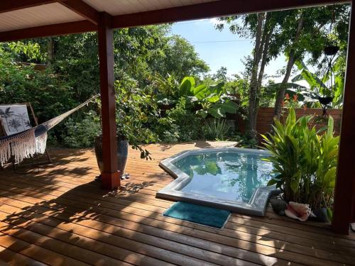 una piscina en una terraza de madera en Bungalow, gîte les fleurs du colibri, en Bouillante
