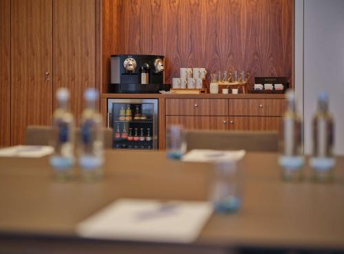 a table in a restaurant with a counter with wine bottles at Dorint Kurfürstendamm Berlin in Berlin
