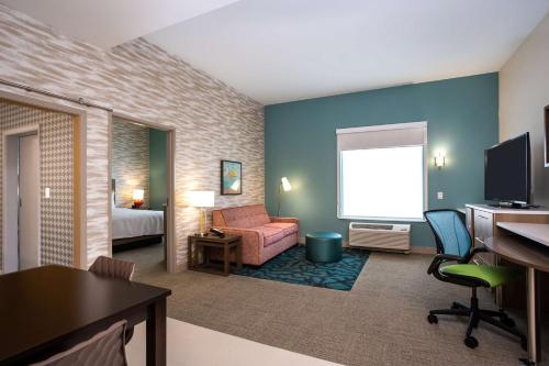 um quarto de hotel com uma cama e uma secretária com um computador em Home2 Suites by Hilton Pflugerville, TX em Pflugerville