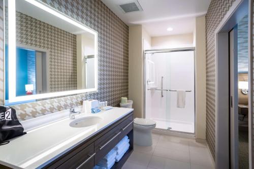 a bathroom with a sink and a toilet and a mirror at Home2 Suites by Hilton Pflugerville, TX in Pflugerville