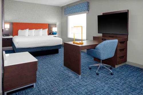 a hotel room with a bed and a desk with a television at Hampton Inn & Suites Cedar Park North Austin, Tx in Cedar Park